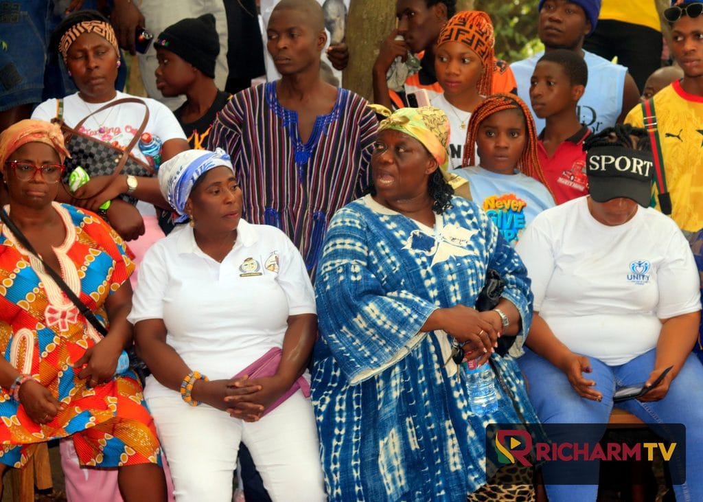 Festival participants gather outdoors in colourful clothing.