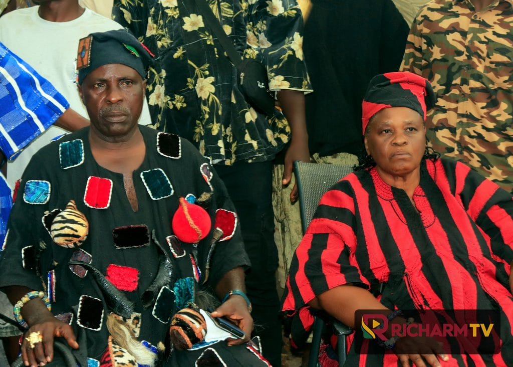 Two festival participants in traditional attire seated together.